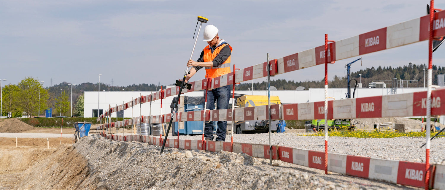 Worker on a construction site with barriers and equipment